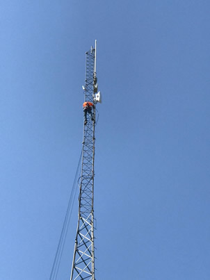 EIT Broadband technician in the field beside a service truck.